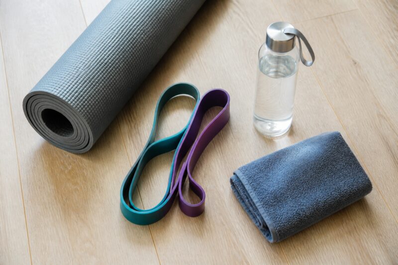 Yogamatte, Theraband und Wasserflasche als minimalistische Home-Workout-Grundlagen.